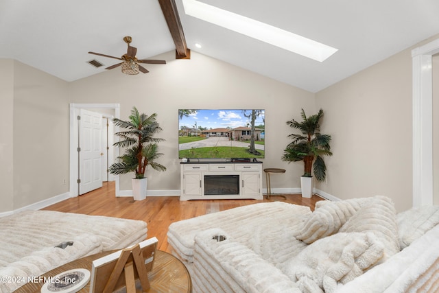 living room with light wood-type flooring, ceiling fan, and lofted ceiling with skylight