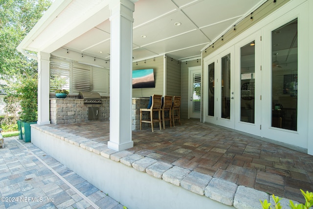 view of patio / terrace with area for grilling, an outdoor bar, and french doors