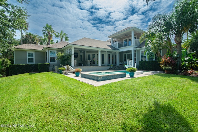 back of house featuring a balcony, a lawn, and a patio