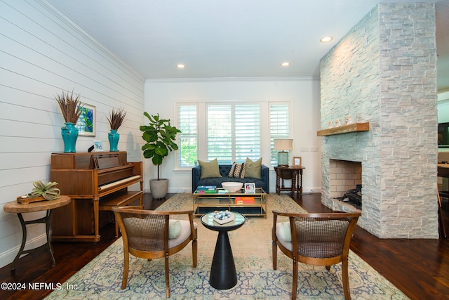 dining room featuring crown molding, a stone fireplace, and dark hardwood / wood-style flooring