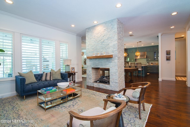 living room with ornamental molding, dark hardwood / wood-style floors, and a stone fireplace