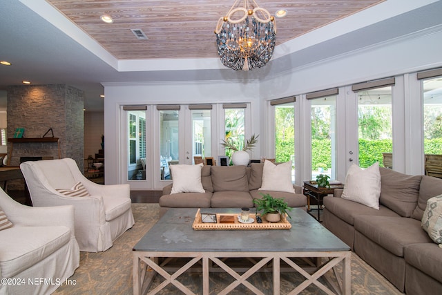 living room with a fireplace, wooden ceiling, french doors, a notable chandelier, and a raised ceiling