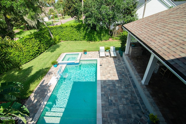 view of pool with a lawn, a patio area, and an in ground hot tub