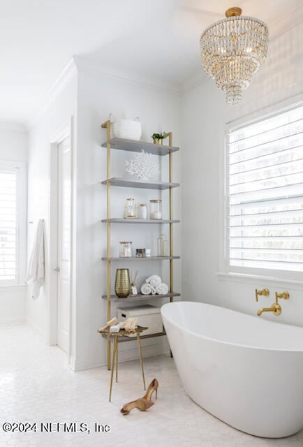 bathroom featuring ornamental molding, a notable chandelier, and a washtub