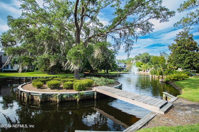 view of dock featuring a water view and a yard