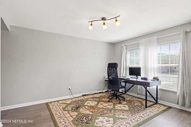 office with hardwood / wood-style flooring and a textured ceiling