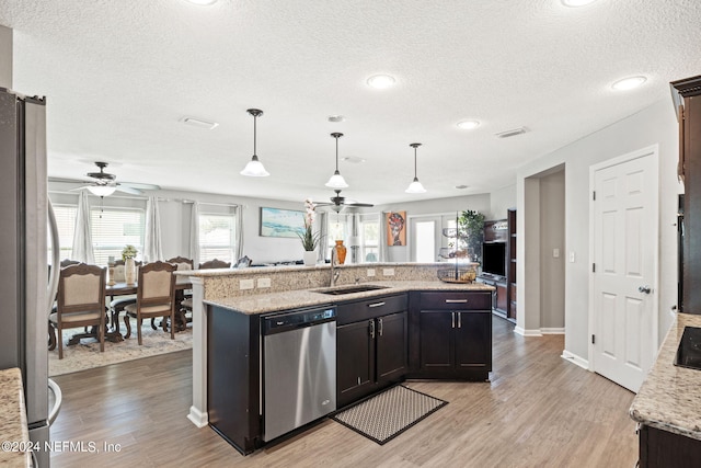 kitchen featuring ceiling fan, an island with sink, appliances with stainless steel finishes, and sink