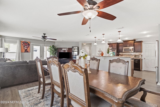 dining space featuring light wood-type flooring, ceiling fan, and sink