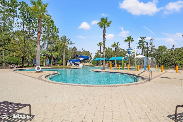 view of swimming pool with a patio and a water slide