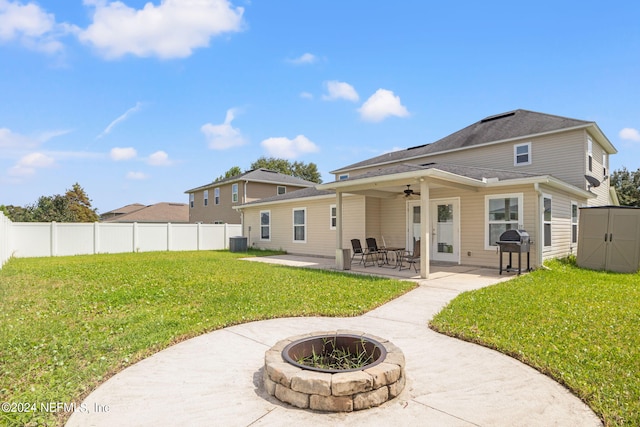 back of property featuring a lawn, ceiling fan, central AC, a patio area, and an outdoor fire pit