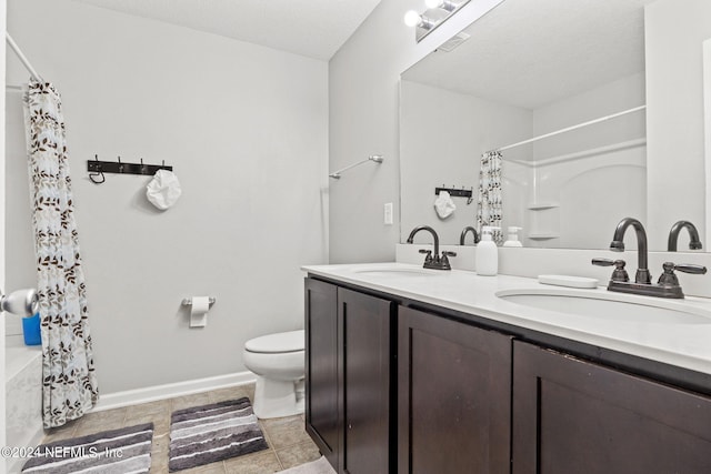 bathroom with tile patterned floors, a textured ceiling, vanity, and toilet