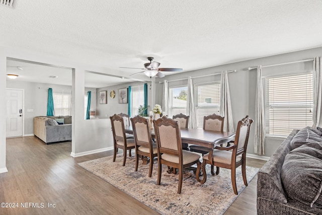 dining room with ceiling fan, a textured ceiling, and hardwood / wood-style floors