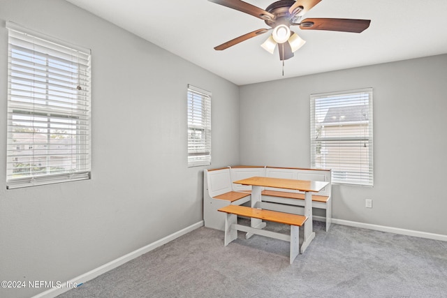 carpeted dining space with a wealth of natural light and ceiling fan