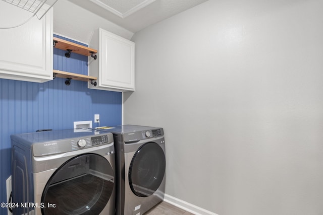 laundry area featuring cabinets, a textured ceiling, hardwood / wood-style flooring, and washer and dryer