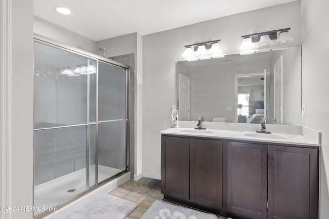 bathroom with tile patterned floors, a shower with door, and vanity