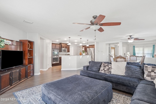 living room with ceiling fan and hardwood / wood-style floors