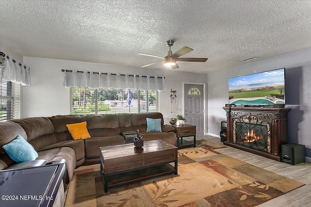 living room featuring a textured ceiling, hardwood / wood-style floors, and ceiling fan