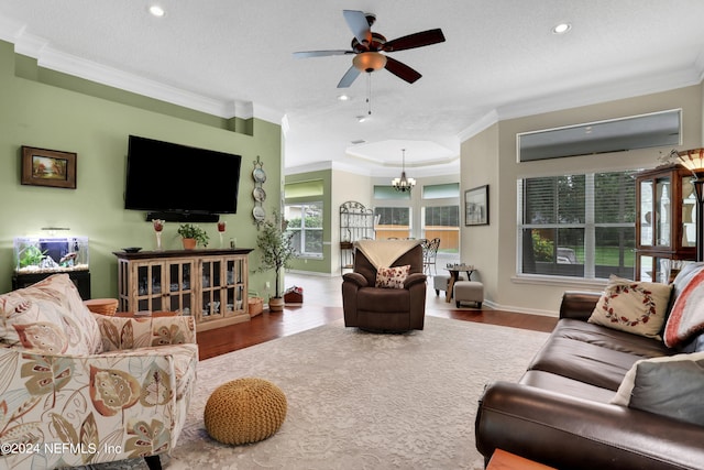 living room featuring ceiling fan with notable chandelier, wood-type flooring, and a textured ceiling