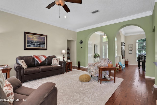 living room with ceiling fan, dark hardwood / wood-style floors, crown molding, and a textured ceiling