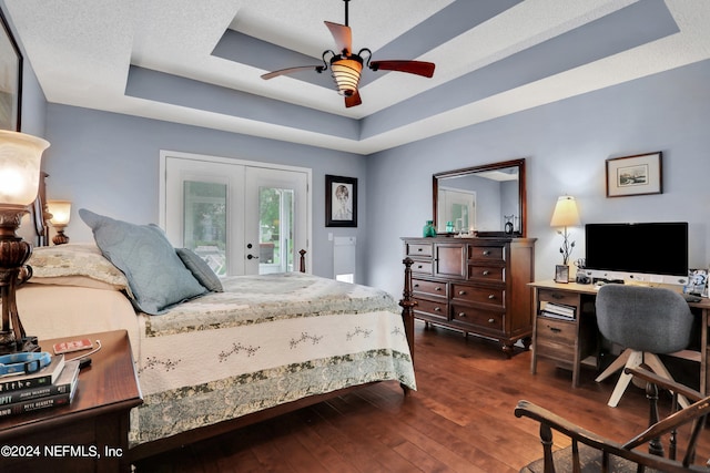 bedroom featuring a raised ceiling, dark hardwood / wood-style floors, french doors, access to outside, and ceiling fan