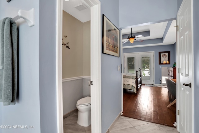 bathroom featuring ceiling fan, toilet, hardwood / wood-style flooring, and french doors