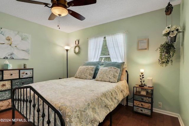 bedroom with a textured ceiling, ceiling fan, and dark hardwood / wood-style floors