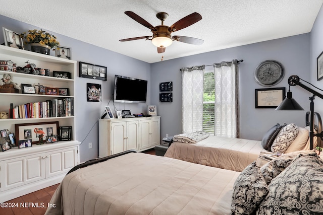 bedroom with a textured ceiling, wood-type flooring, and ceiling fan