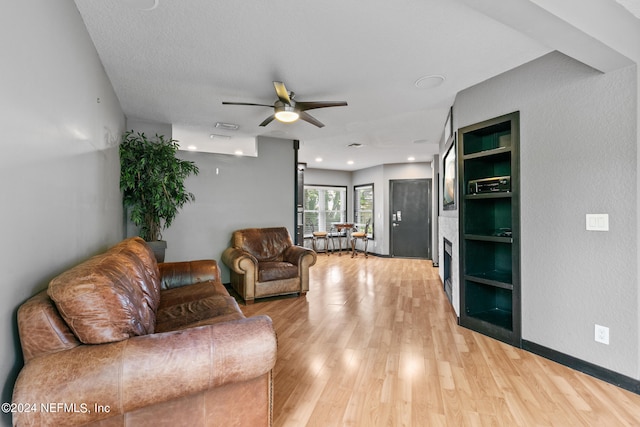 living room with ceiling fan and light hardwood / wood-style floors