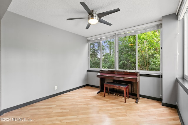 miscellaneous room featuring light wood-type flooring, a textured ceiling, and ceiling fan