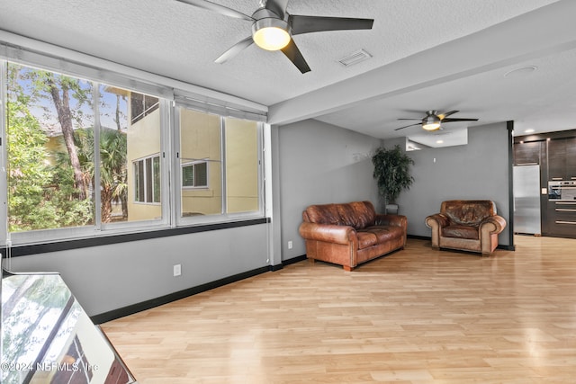 interior space with a textured ceiling, light hardwood / wood-style flooring, and ceiling fan