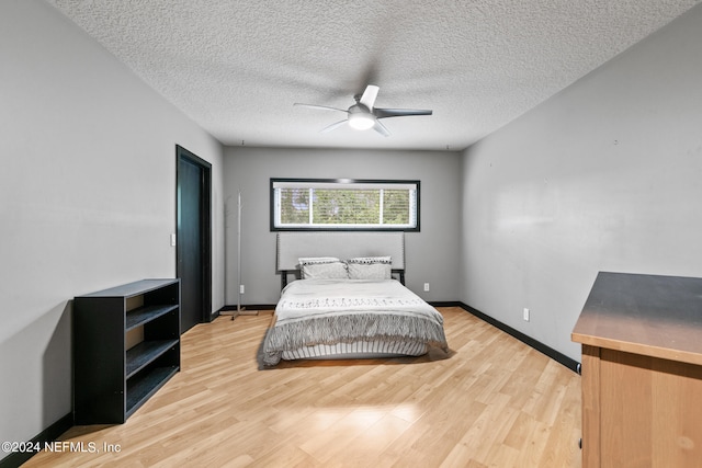 bedroom with a textured ceiling, light hardwood / wood-style flooring, and ceiling fan