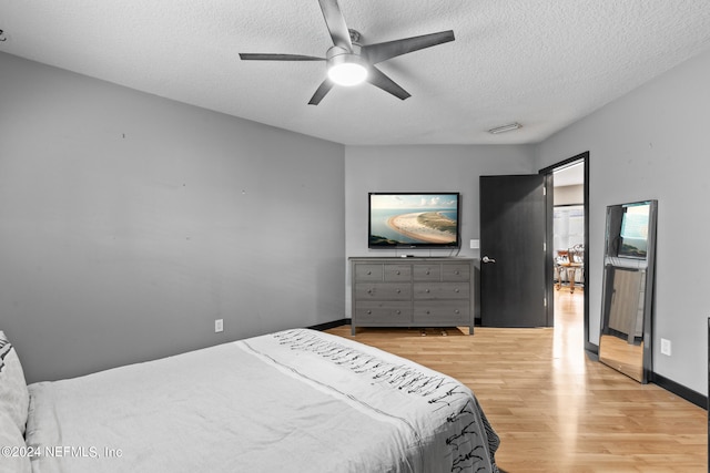 bedroom featuring a textured ceiling, light hardwood / wood-style flooring, and ceiling fan