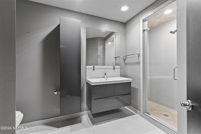 bathroom featuring vanity, walk in shower, tile patterned flooring, toilet, and decorative backsplash