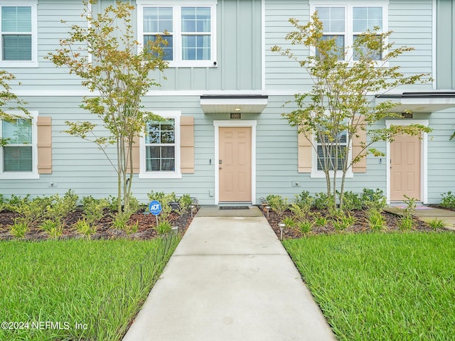 view of exterior entry with a yard