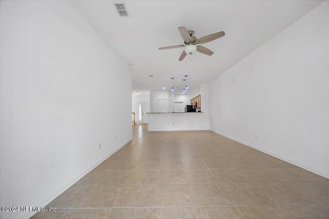 unfurnished living room featuring ceiling fan and light tile patterned floors