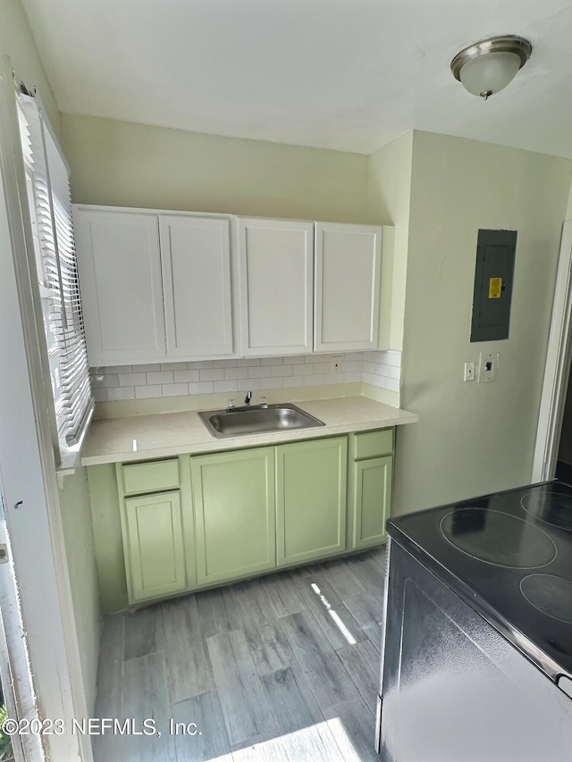 kitchen with tasteful backsplash, sink, electric panel, black range with electric cooktop, and light wood-type flooring