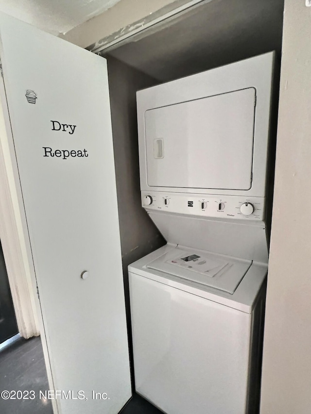 clothes washing area with stacked washing maching and dryer