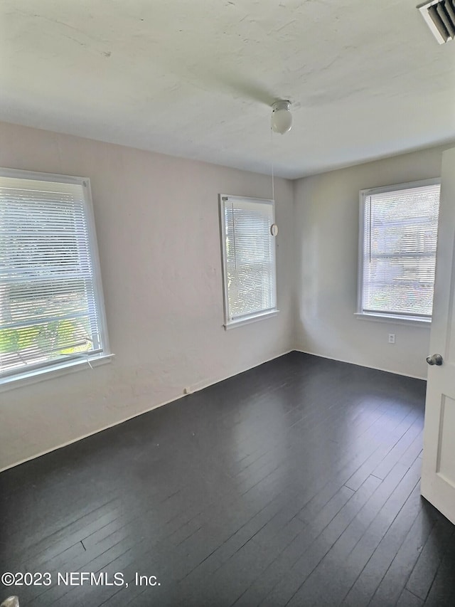 unfurnished room with dark hardwood / wood-style flooring