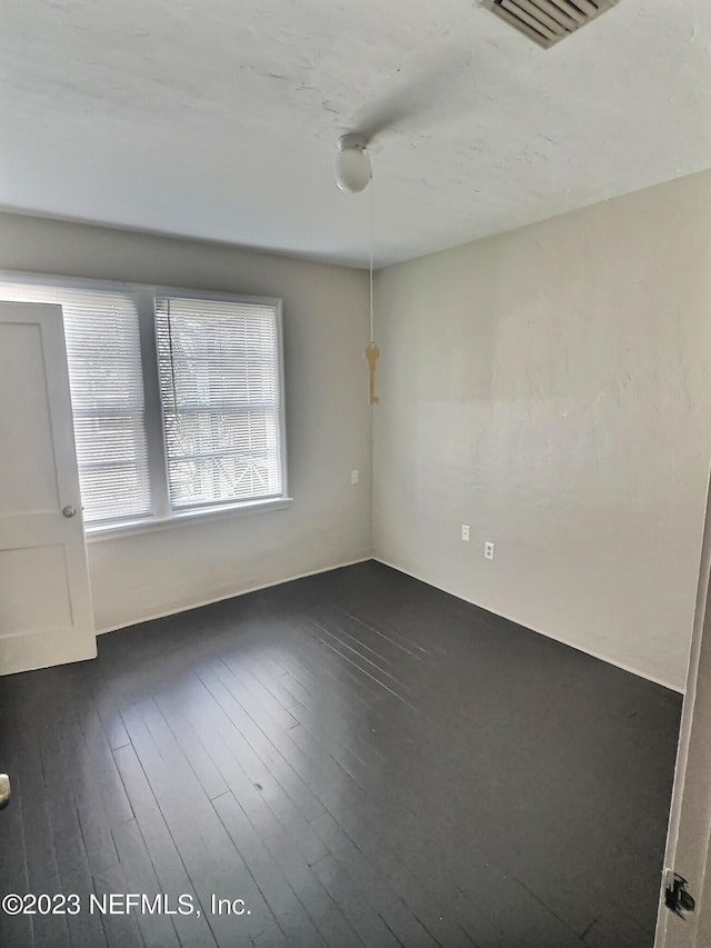 empty room with dark hardwood / wood-style flooring