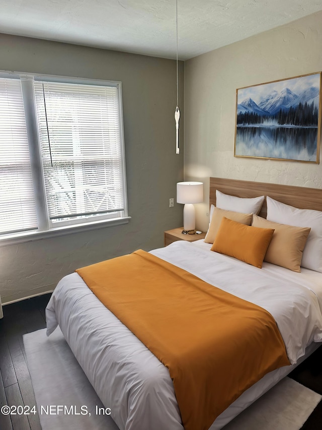 bedroom featuring dark hardwood / wood-style floors and a textured ceiling