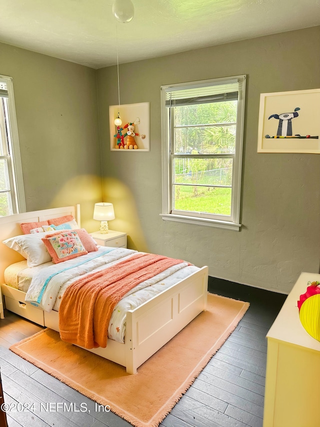 bedroom featuring wood-type flooring and multiple windows