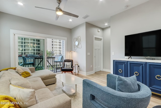 living room featuring light hardwood / wood-style flooring and ceiling fan