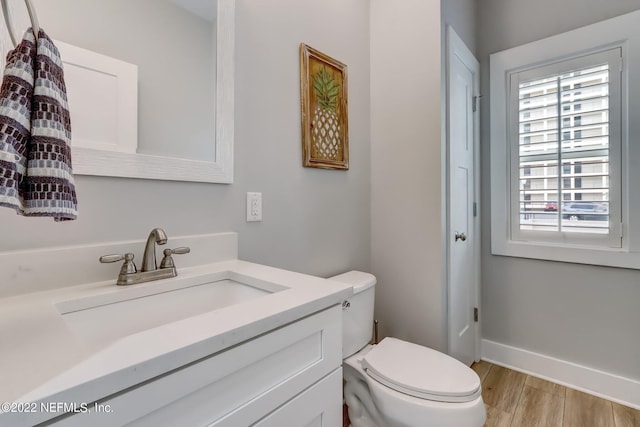 bathroom with vanity, toilet, and hardwood / wood-style floors