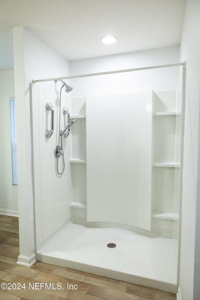 bathroom with a shower and hardwood / wood-style floors