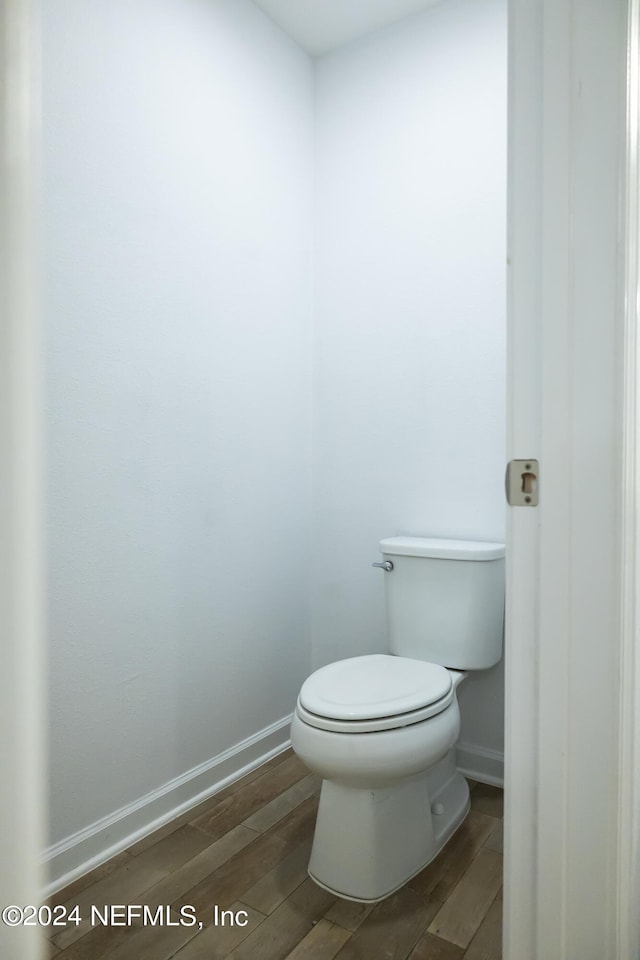 bathroom featuring hardwood / wood-style flooring and toilet