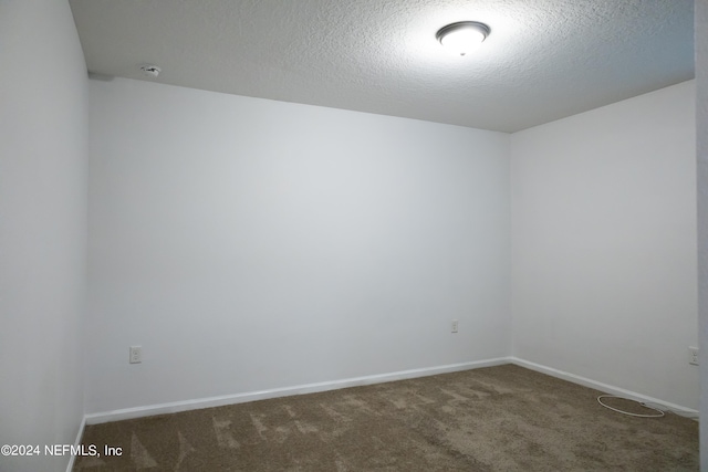 carpeted empty room with a textured ceiling