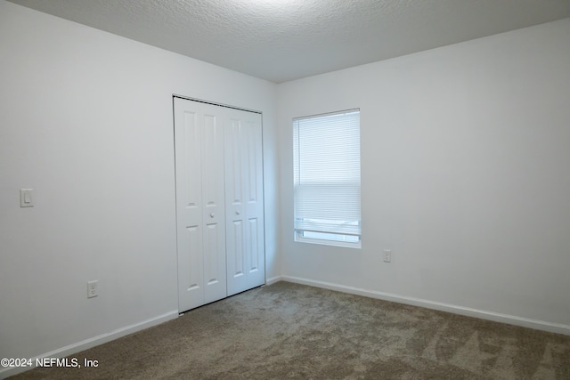 unfurnished bedroom with multiple windows, a closet, and carpet