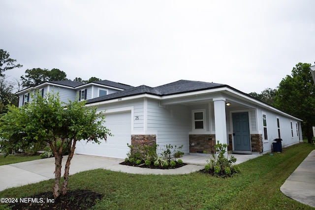 view of front of home with a front yard, a garage, and covered porch