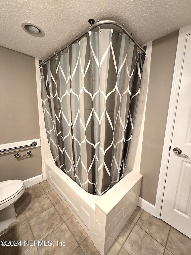 bathroom featuring tile patterned flooring, toilet, shower / tub combo with curtain, and a textured ceiling