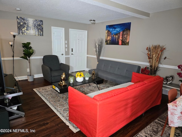 living room featuring beamed ceiling, dark hardwood / wood-style flooring, and a textured ceiling